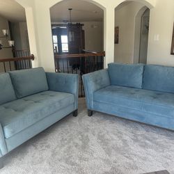 Beautiful blue matching love seat couches.