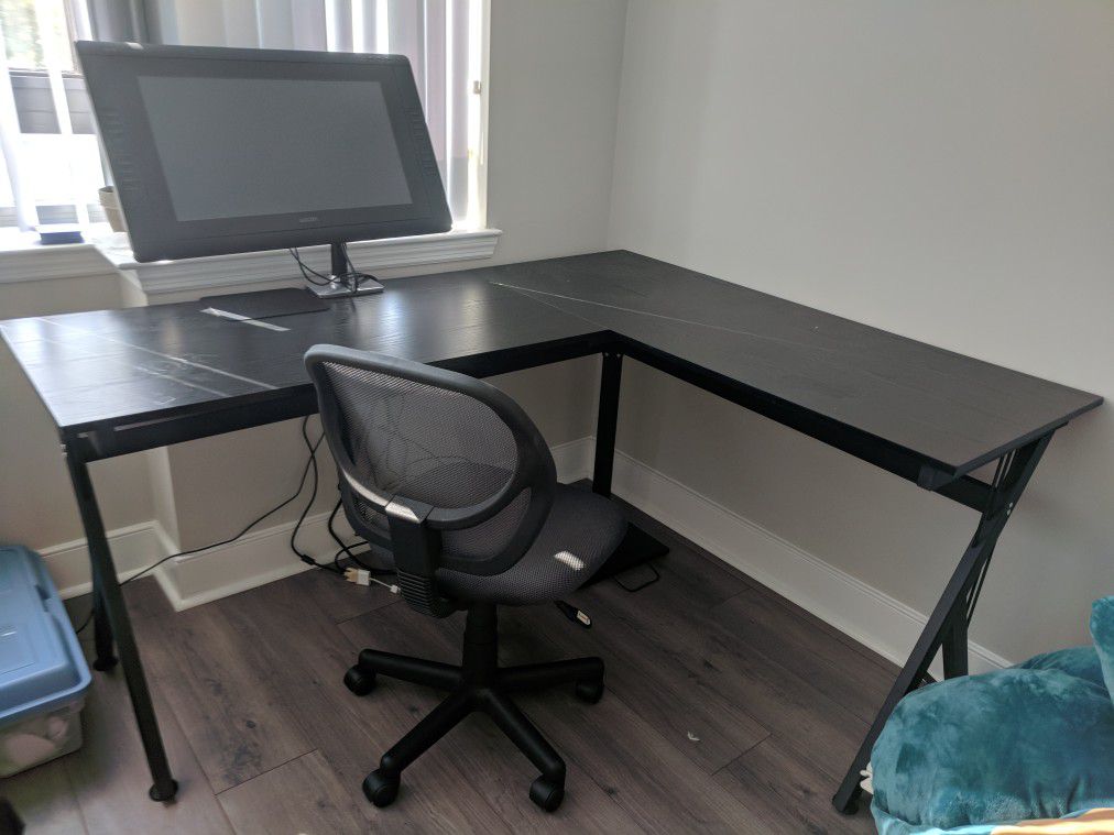 L shaped black desk with chair