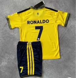 Ronaldo kids sizes 22,24,26,28 set Al-Nassr soccer kit includes a yellow jersey and navy blue shorts. The jersey has the name CRISTIANO 'RONALDO' and