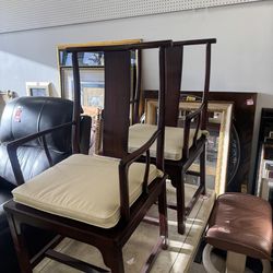 Pair of Ming-style armchairs featuring dark wood frames and upholstered cushions