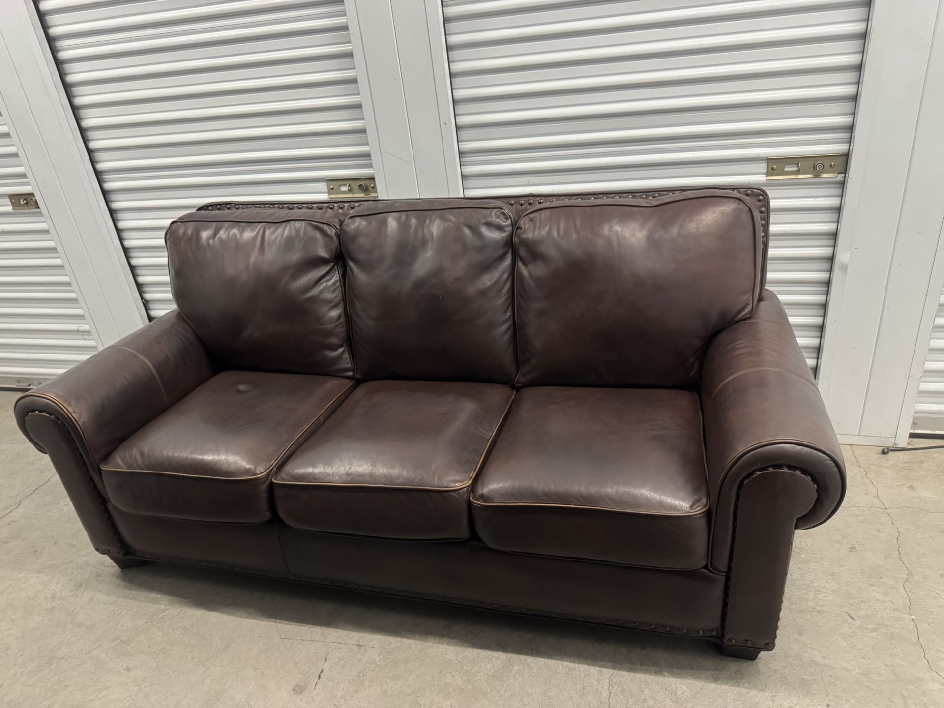 BROWN TOP GRAIN LEATHER SOFA WITH NAILHEAD TRIMS.