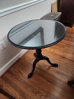 Glass top round wood table with claw feet