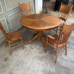 Classic solid oak round pedestal table with matching pressed back  spindle chairs