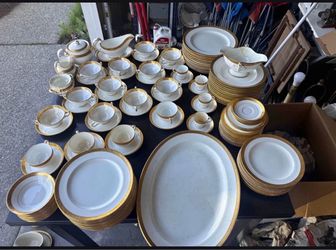 Extensive white porcelain dinnerware set with gold-trimmed borders. Includes dinner plates, salad plates, saucers, teacups, soup bowls, a covered ture