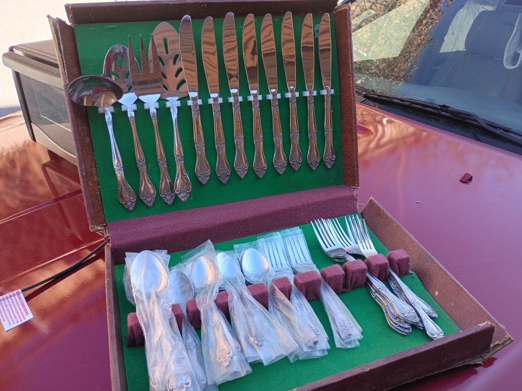 Complete boxed stainless steel flatware set with serving pieces included.
