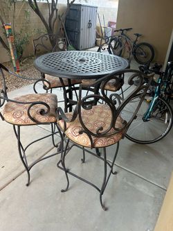 Outdoor bar-height patio table set including 1 cast aluminum table + 4 matching cast aluminum chairs with custom upholstered seat pads.
