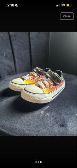 Converse Chuck Taylor All Star toddler shoes featuring a black upper with a prominent orange and red flame graphic