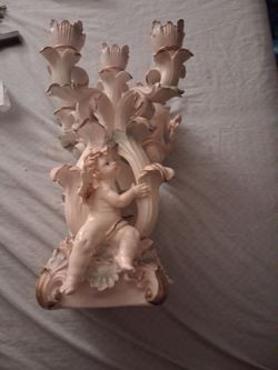 Vintage  porcelain candle holders surrounded by angels