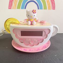 HELLO KITTY CLOCK/RADIO/ALARM!! SHAPR OF A. UP OF TEA  WITH A SLICE OF LEMON! EXCELLENT CONDITION !! PLUG IN