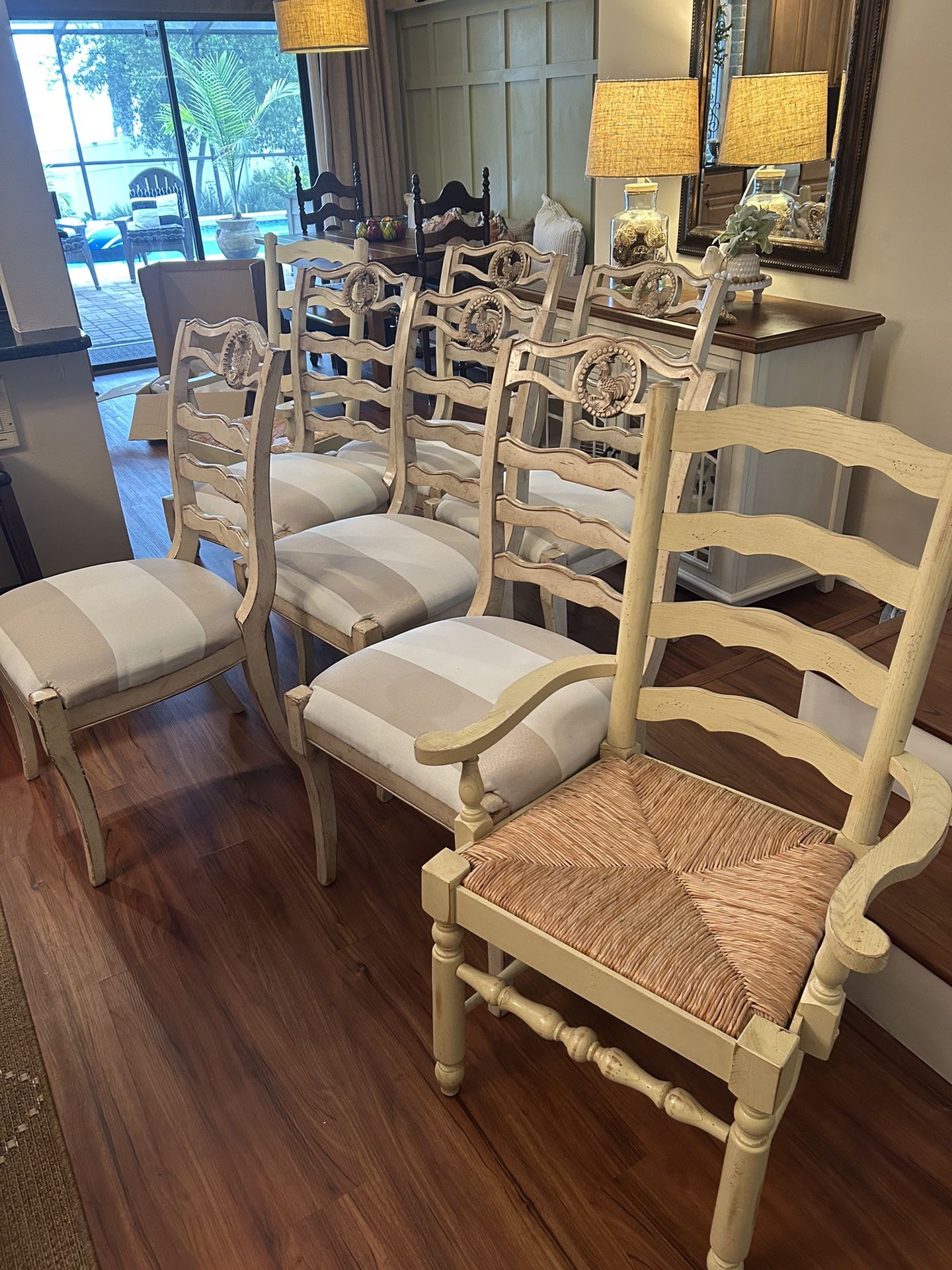 6 French Country Distressed Dining Room Chairs w/rooster motif. And 2 Armed Ladder Back Chairs