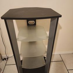 Entertainment center or TV stand with a black frame and frosted glass shelves. 