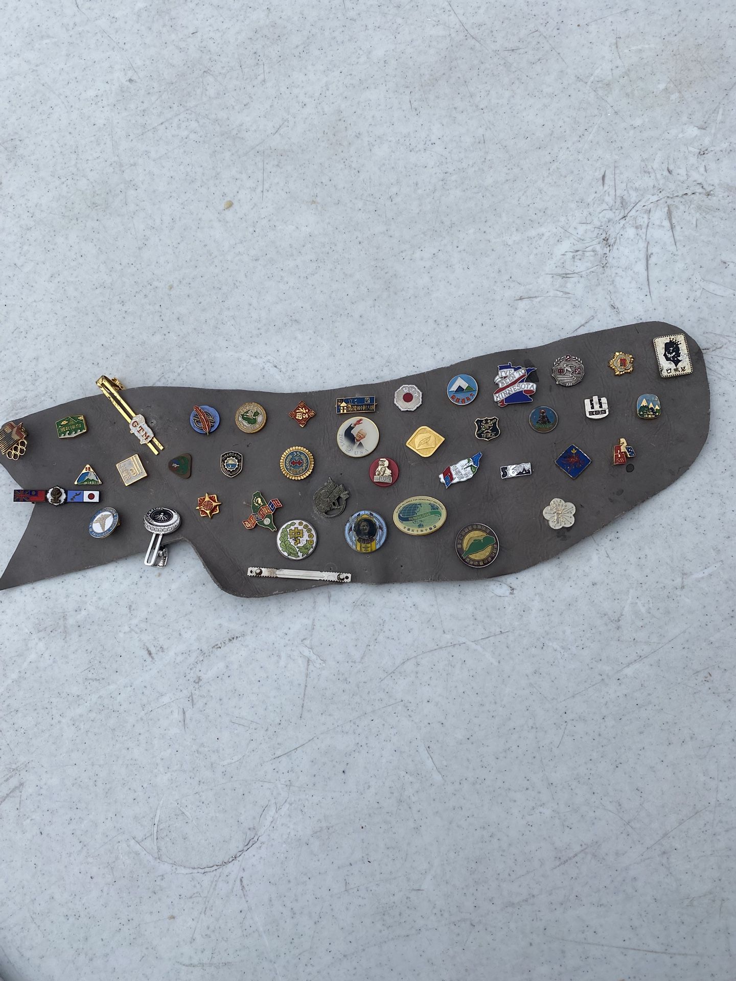 Vintage Collectable Pins On A Leather Canvas