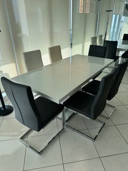 Modern white gloss dining set features a sleek rectangular extension table paired with contemporary cantilever dining chairs with chrome sled bases.