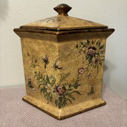 Diamond-shaped, footed ceramic jar with a lid.