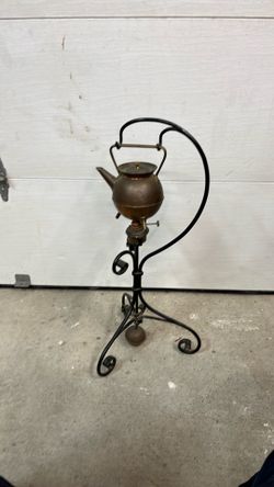 This is a 19th-century Arts and Crafts spirit kettle, often attributed to designer Christopher Dresser