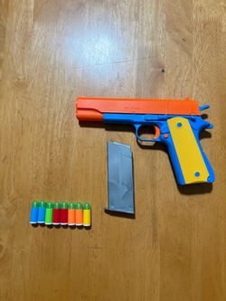 Spring-loaded Plastic Colored Toy M1911 gun. NOTE: It’s a toy gun. Not a real gun. Everything Must Go!/Moving Sale