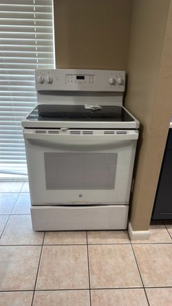 GE white 30-inch electric range with a glass/smooth cooktop.