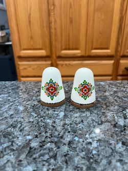 Ceramic Vintage  Floral Design pair of salt and pepper shakers.  The bottom Is wood.  One of the cork stoppers is chipped due to age.  Size approximat