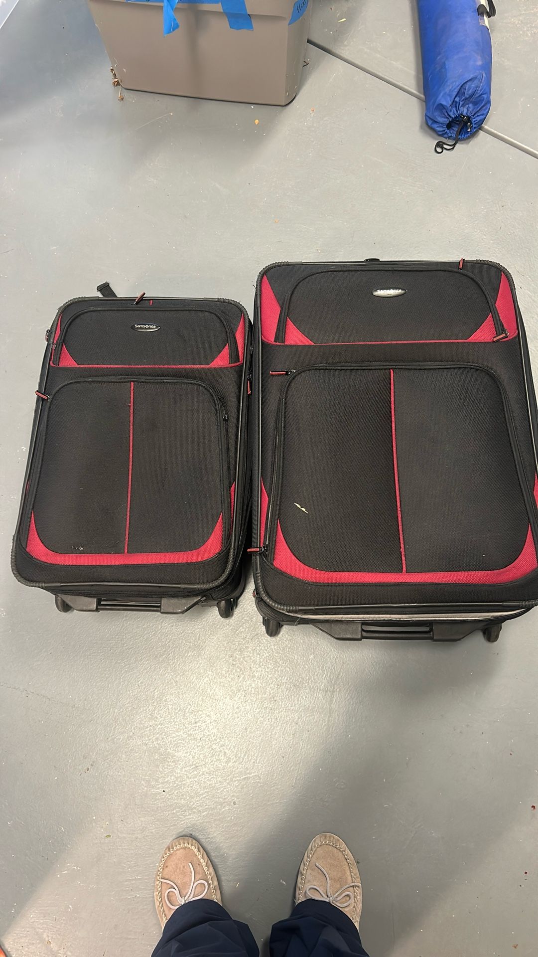 Two red and black matching Samsonite suitcases with wheels both expand