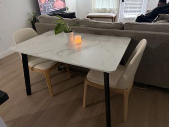 Extendable marble table with two cream faux leather chairs