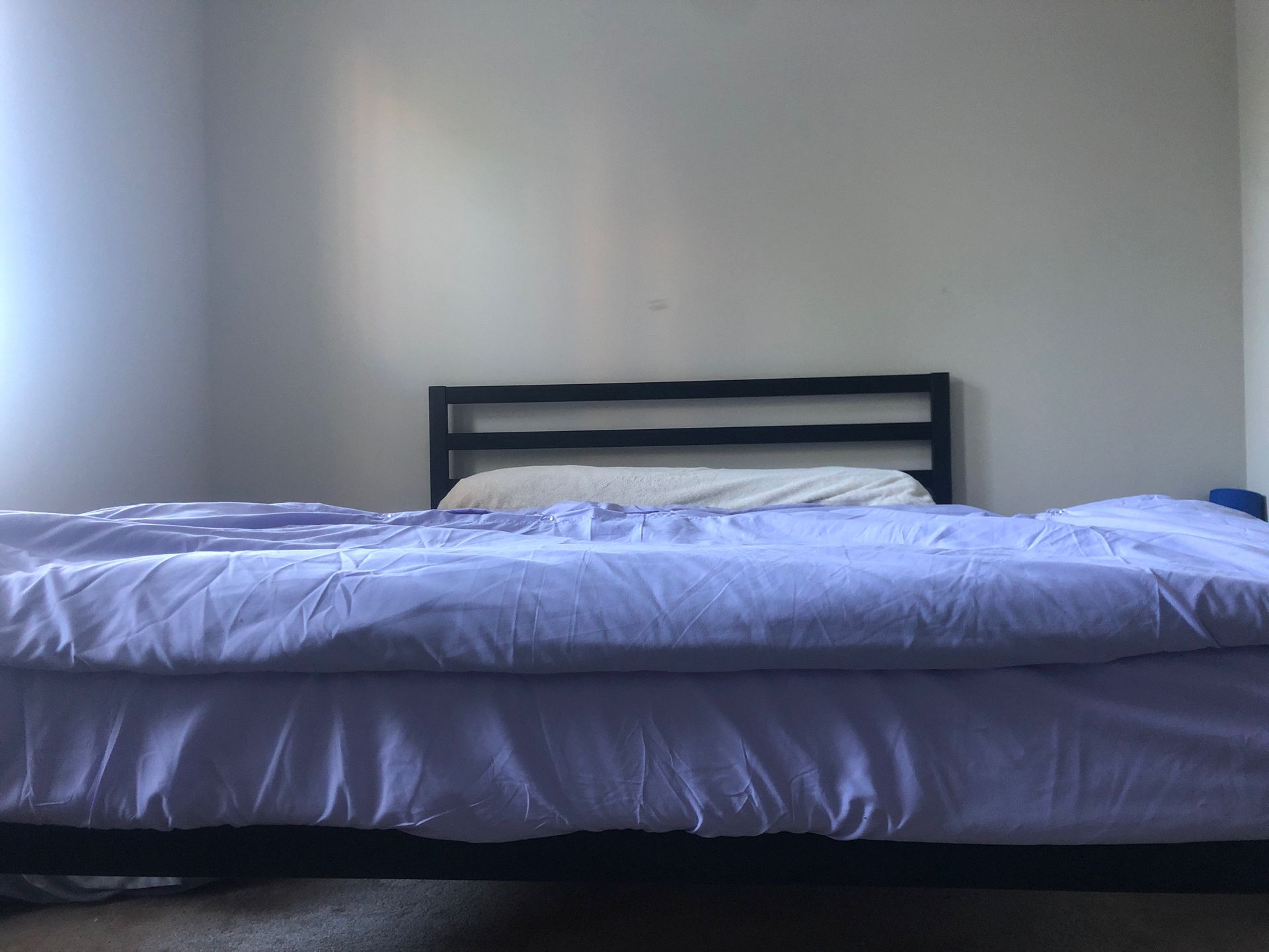 Black queen sized bed frame, mattress, and foam topper