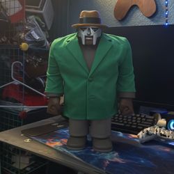 The figure in the image is the MF DOOM x Madlib SuperSize Madvillain Vinyl Figure by Super7.