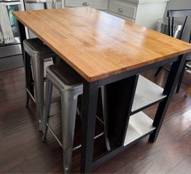 Solid wood kitchen island with metal lined shelves.