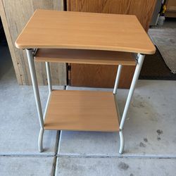 This is a compact computer desk with a manufactured wood top, a steel frame, and a pull-out keyboard tray.