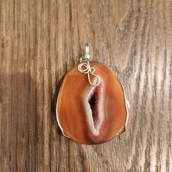 unique semi-translucent orange agate geode slice pendant with a wire-wrapped silver-plated edge, great condition 