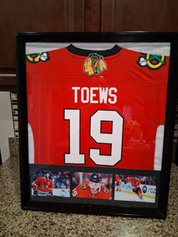 JOHNATHAN TOWES OF THE CHICAGO BLACK HAWKS, STITCHED,BRANDED,AUTHENTIC FRAMED SIGNED JERSEY.
