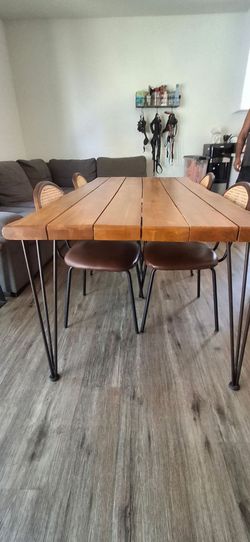 Wooden table with 4 wicker/faux leather chairs.