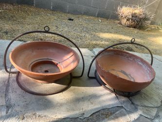 Two terracotta planters with wrought iron hangers