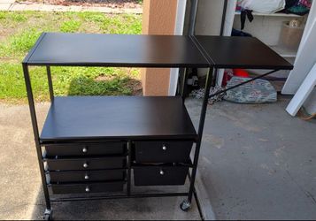 Black rolling storage cart with expandable countertop. Six drawers storage