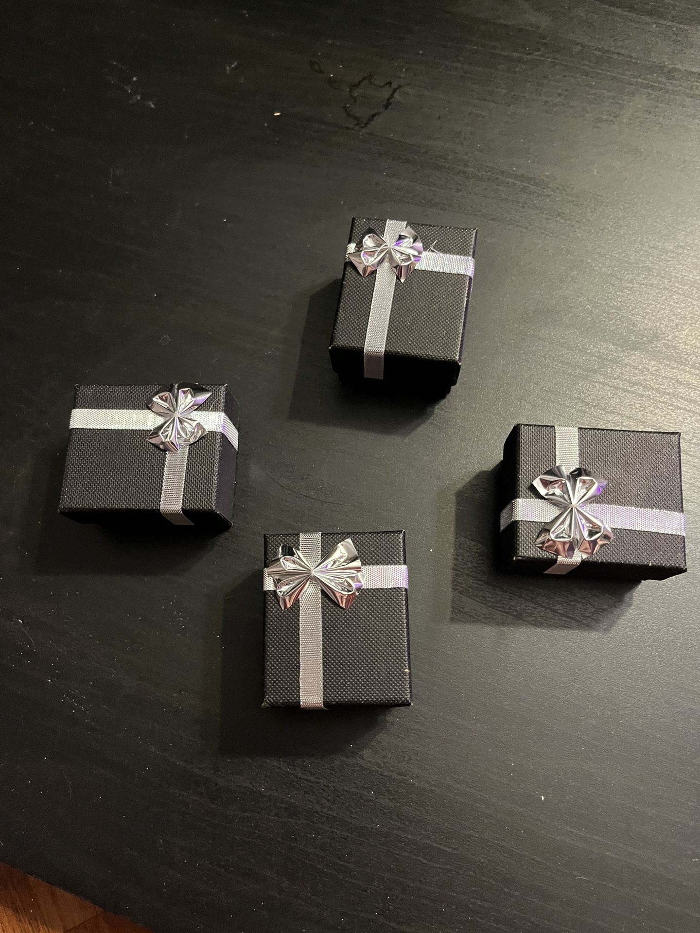 Four Black Ring Boxes With Silver Bow