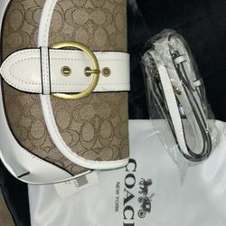 Brown and white handbag with gold buckle.