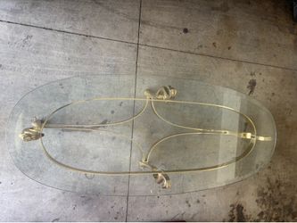 Oval brass hoof feet horse heads base glass top coffee table.