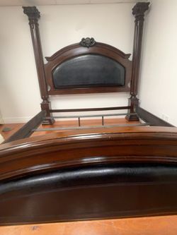 Dark Wood Four-Post Bed Frame with Upholstered Panels
