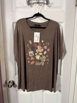 Lane Bryant Women’s Size 26 / 28 EveryWear Glitter Minnie Mouse Fall Leaves Graphic Tee features a cozy brown jersey knit and a sparkly autumn-themed 