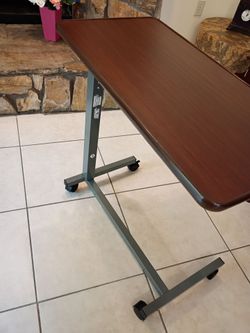 Adjustable height rolling table . Very good condition.