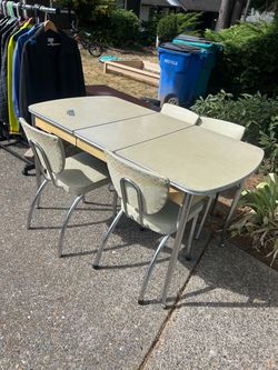 Mid-century modern dinette with chairs in good condition. Comes with a leaf for the center and three solid chairs and one that needs a little bit of h