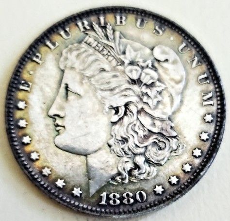 This 1880-Morgan Silver Dollar is a stunning piece of American history. Minted  and Pfeaturing full breast feathers, this circulated