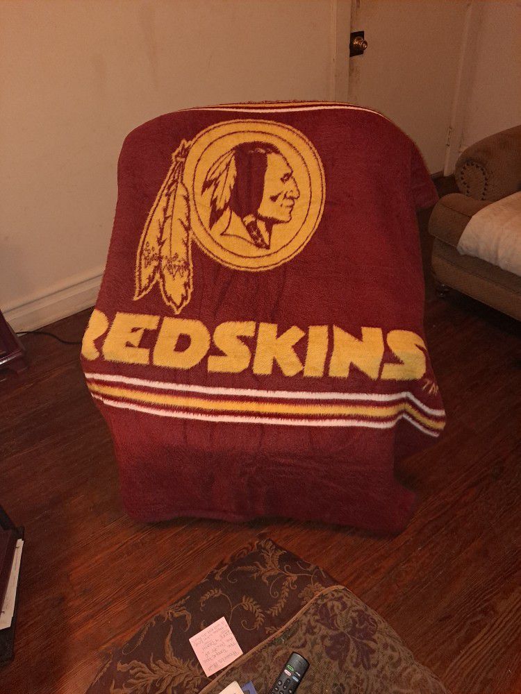 A fleece Blanket With Red Skin Logo On It