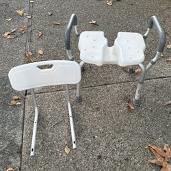 White adjustable shower chair with backrest and arm support. 