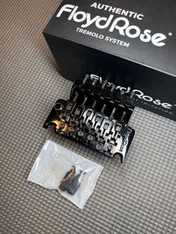 Authentic Floyd Rose 1000 gloss black tremolo in great condition. Comes with fat brass block, matching saddles, saddle and string lock screws + string