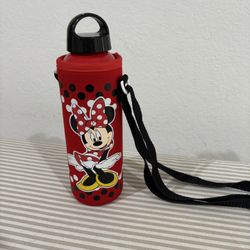 Minnie Mouse water bottle with a red, polka-dotted carrier and a black shoulder strap. 