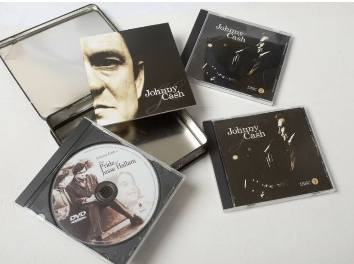Johnny Cash in collectible tin - 2 music CDs and The Pride of Jesse Hallam DVD 1981 Movie and a mini biography book - gently used condition