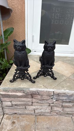 pair of cast iron black cat fireplace andirons (also called fire dogs) with decorative glass eyes.