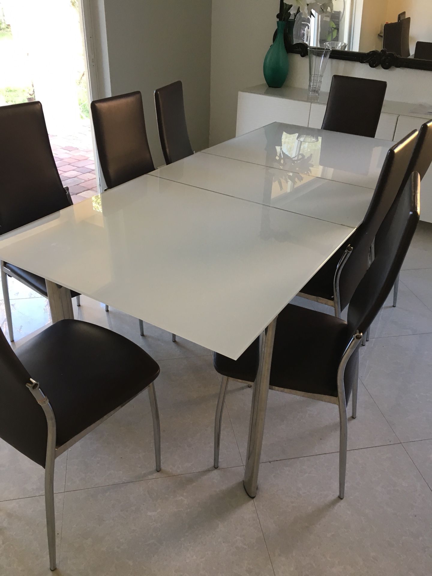 Modern style glass dining table for 8 with 8 chairs, converts to 6 by sliding middle.