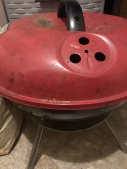 Used red charcoal grill with vented lid