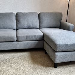 Super comfy greyish blue tLiving Spaces Sofa with Reversible Chaise - less than 1 year old